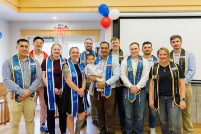 A group of 11 student veterans wearing stoles representing their military service at the Virginia Tech veterans achievement ceremony.