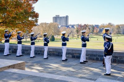 Cadets in dress uniforms perform a rifle salute from the Pylons above the War Memorial Chapel.